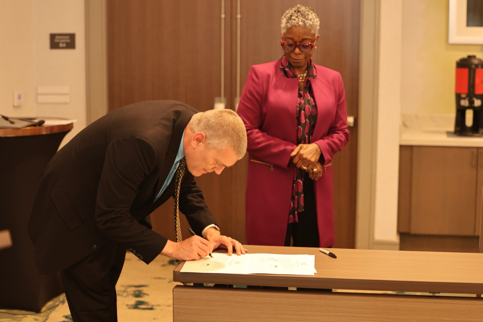 Newly sworn-in Atlantic Circuit Public Defender Joshua Brockington signs his official oath certificate alongside Executive Director Omotayo Alli.